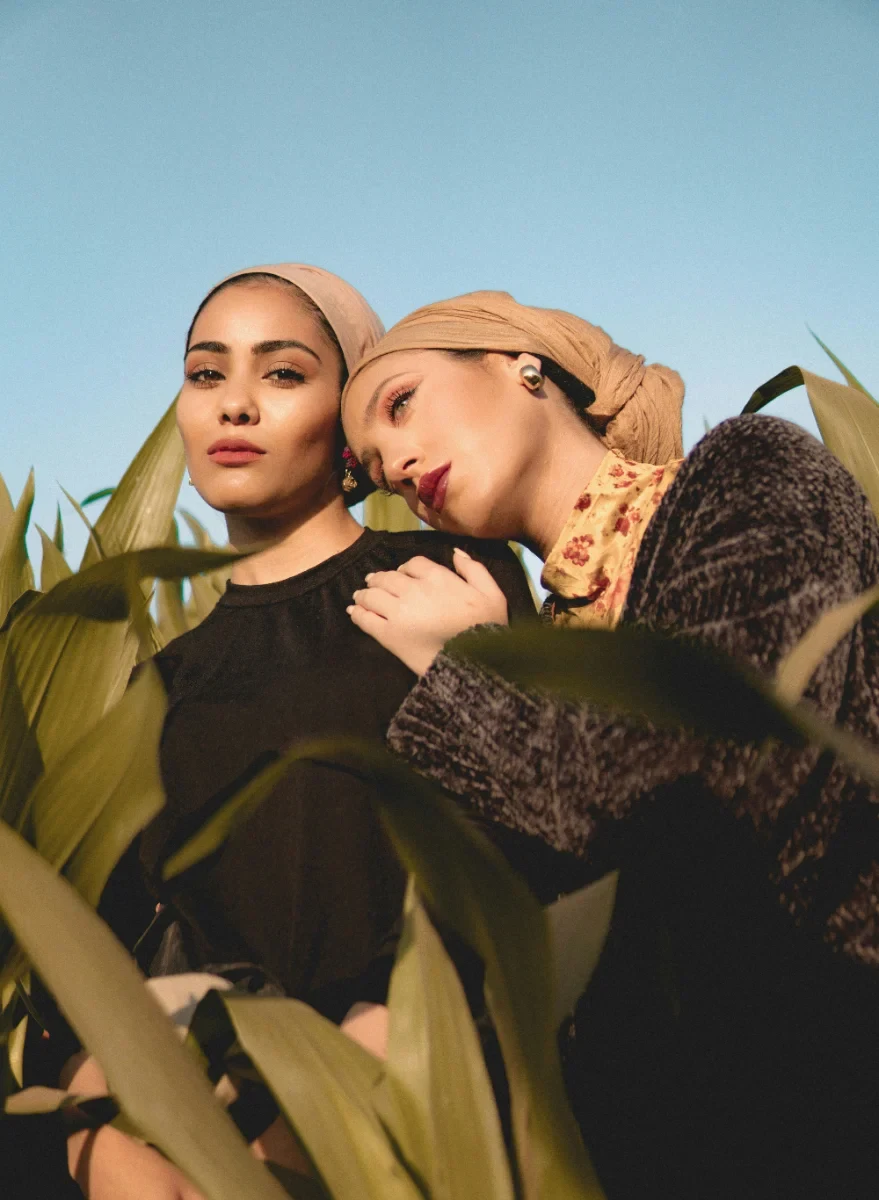 Two women in a field under blue sky